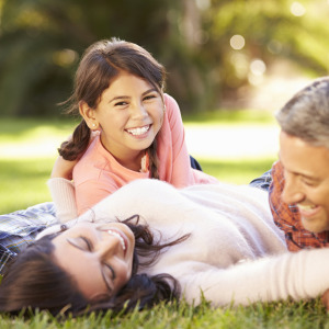 Family of four laying in the grass laughing